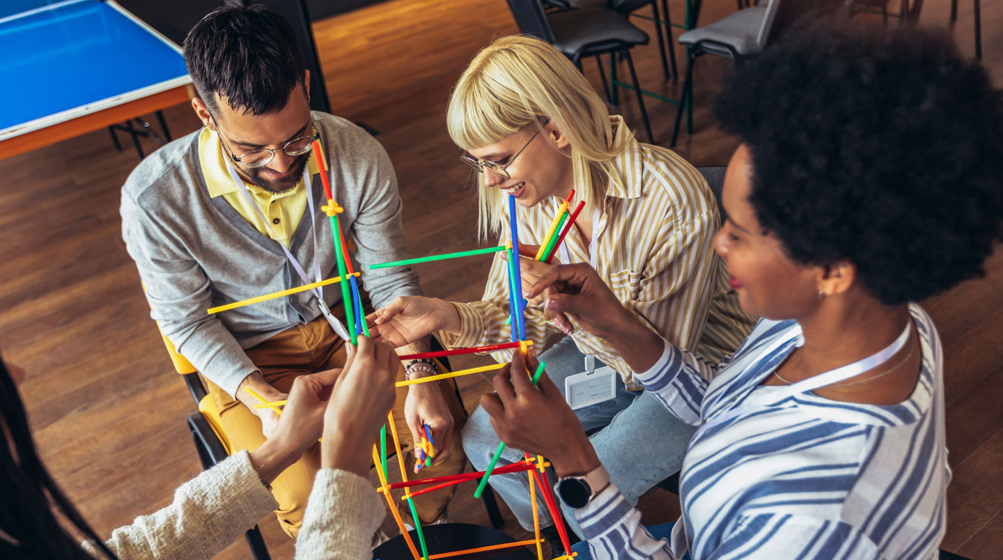 Équipe de collaborateurs construisant ensemble un objet lors d'un défi outdoor de team building